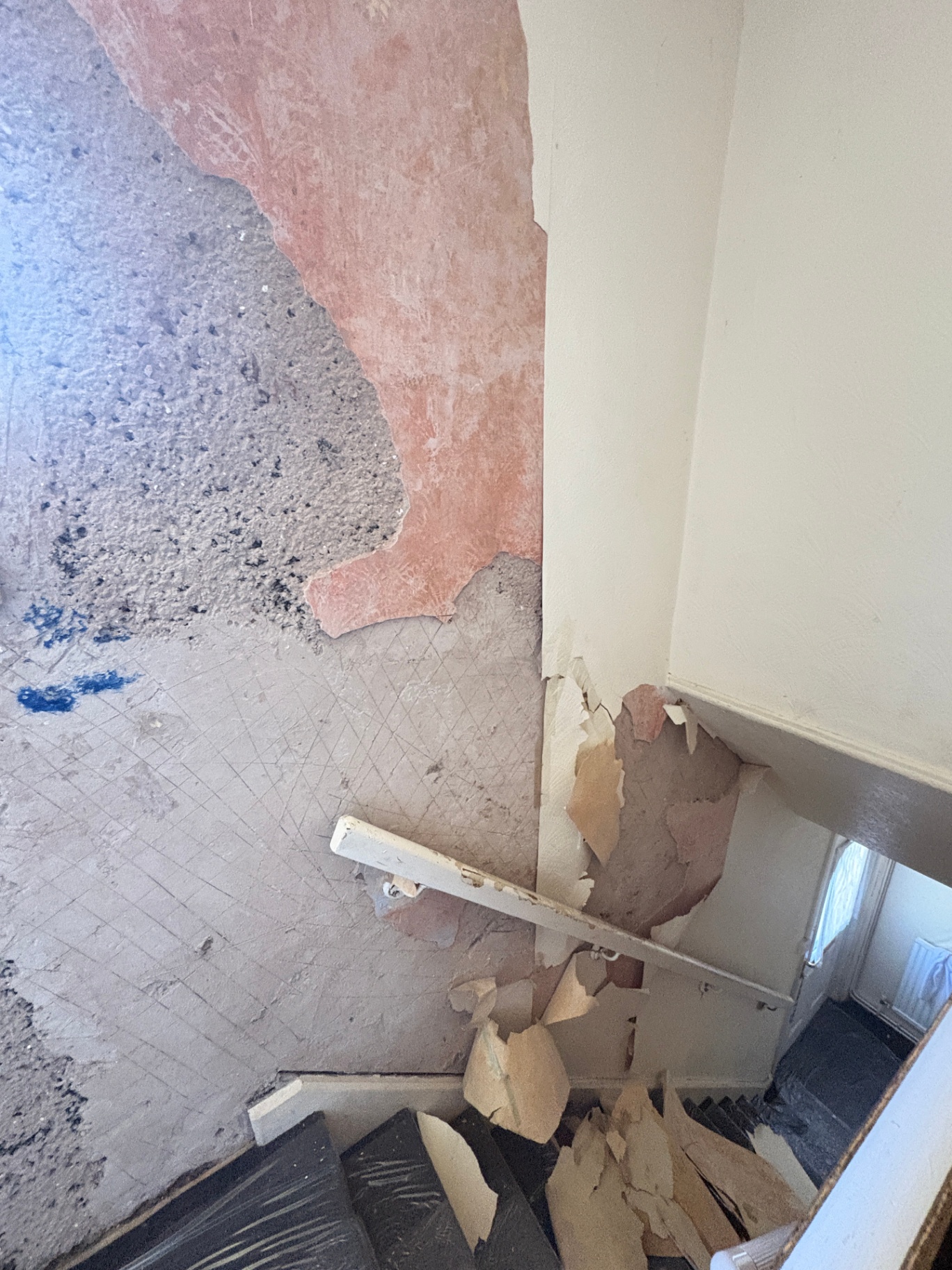 Stairwell repair before — damaged plaster close-up